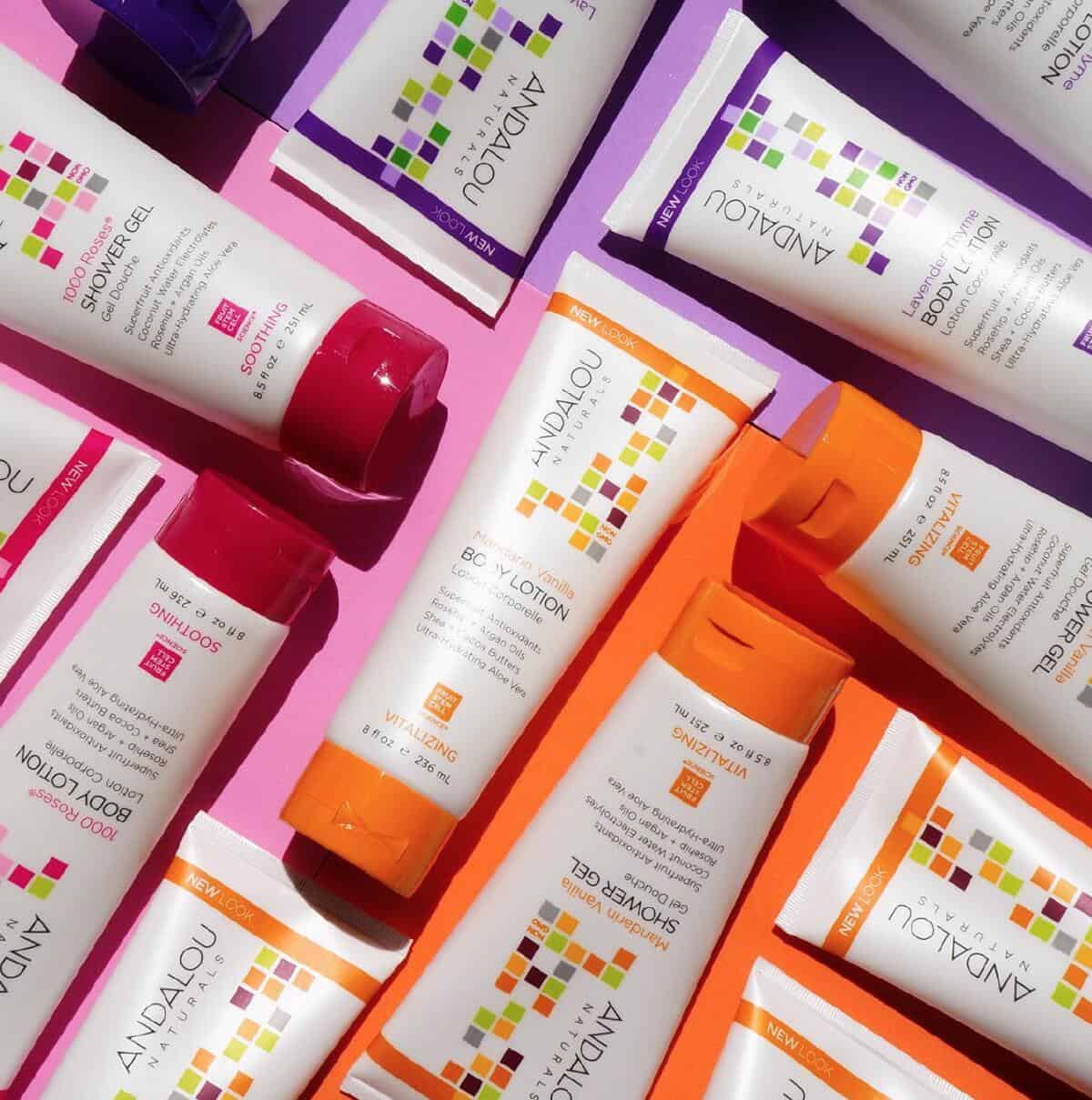A puzzle arrangement of Andalou Naturals body lotions and shower gels on a hot pink background. 