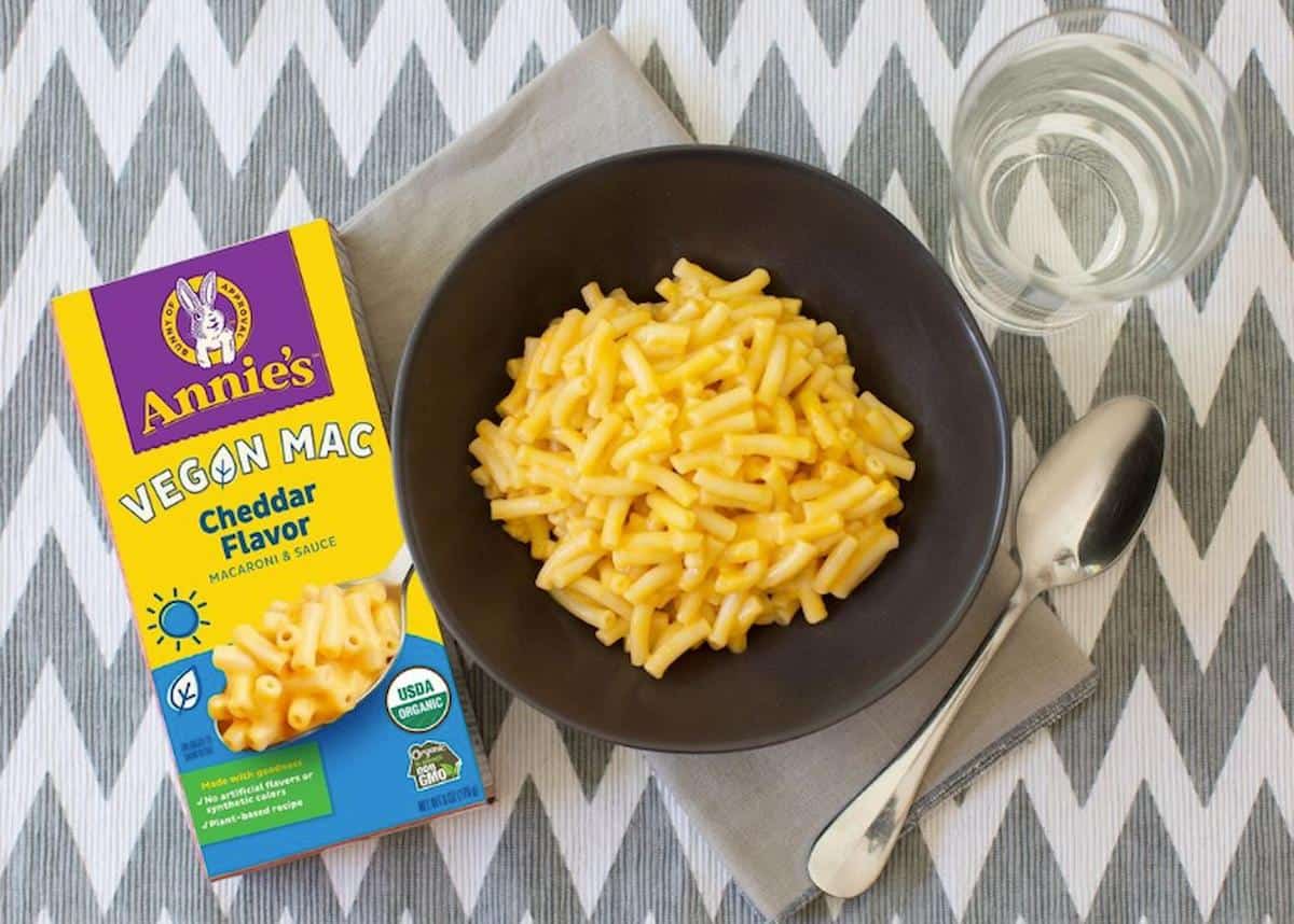 A box of Annie's Vegan Mac next to a bowl of mac and cheese.