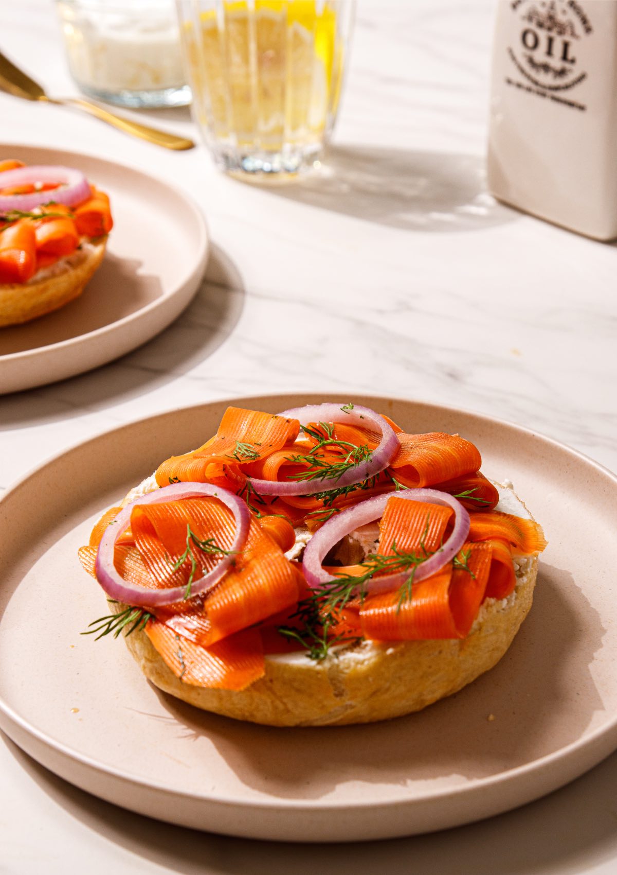 A breakfast table with Jewish bagels with cream cheese and homemade carrot lox. 