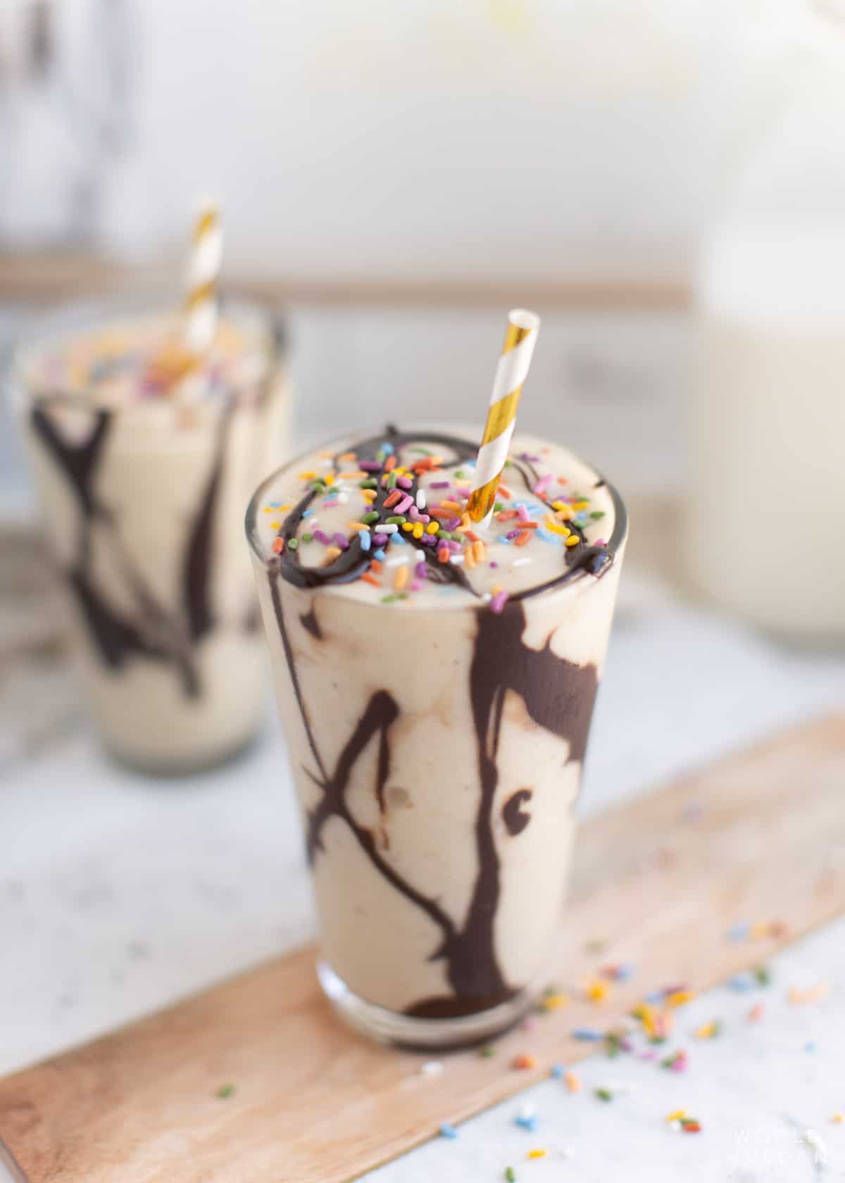 Two banana milkshakes on a countertop.