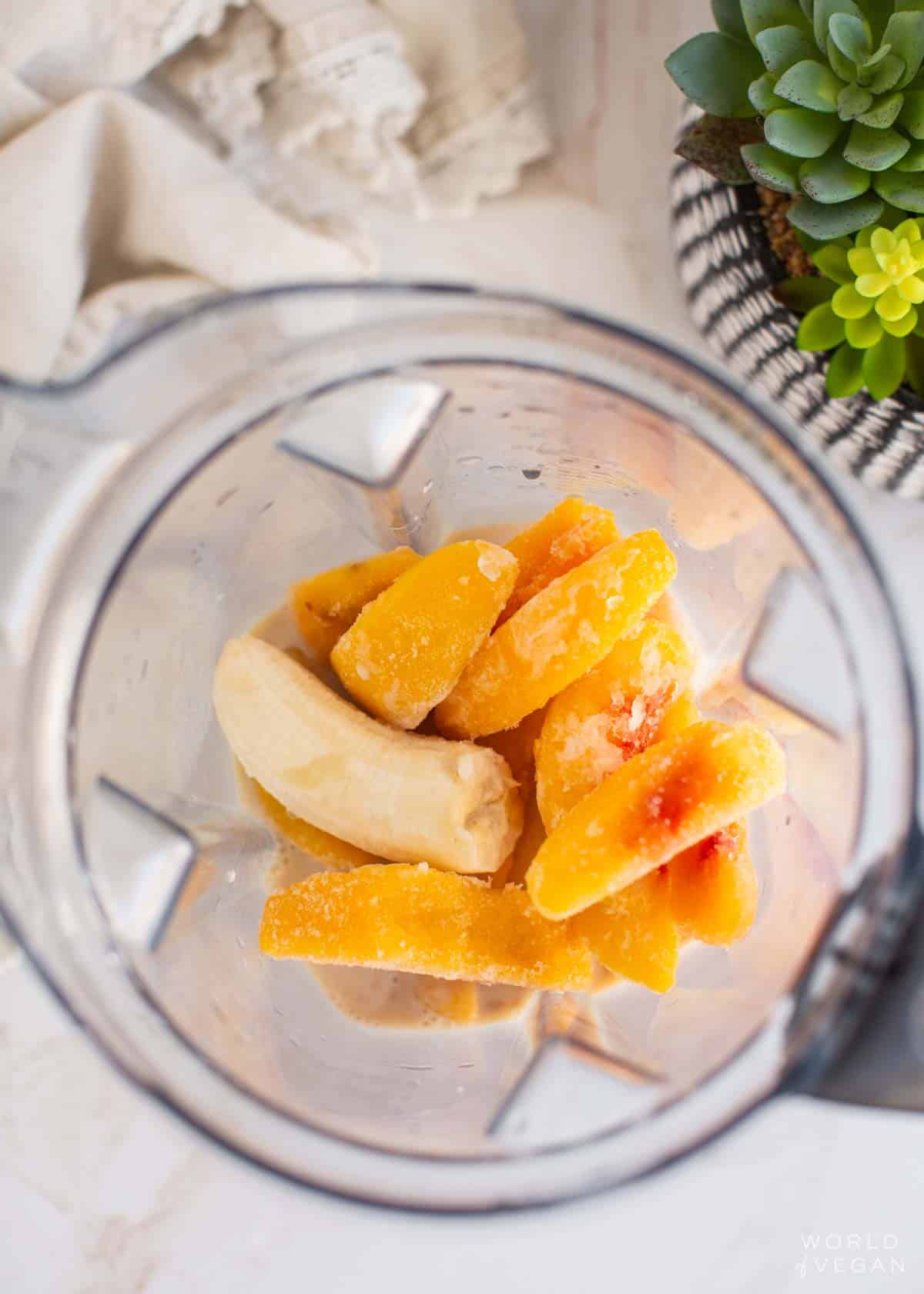 Ingredients for this banana peach smoothie added to a blender pitcher.