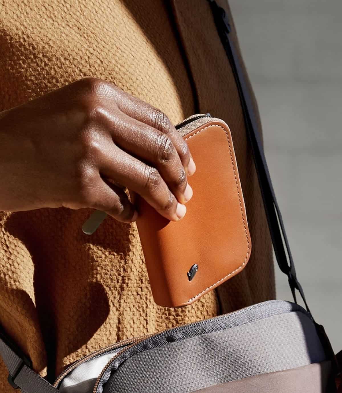 A hand holding a Bellroy brand vegan wallet.