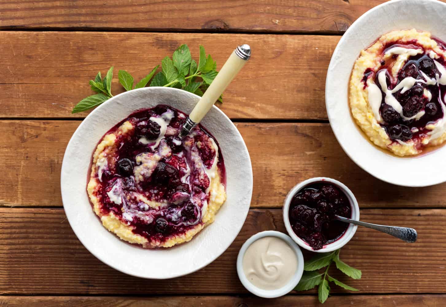 Vegan berry polenta in a bowl with a spoon.