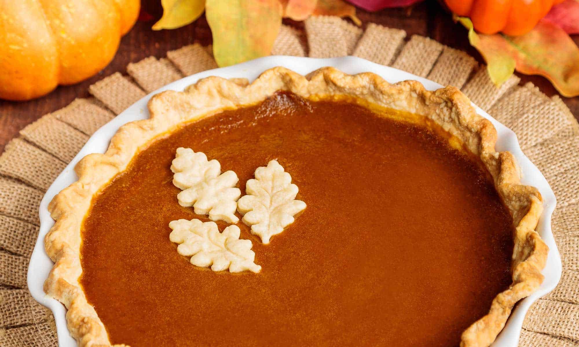 vegan pumpkin pie with fall decorations around it