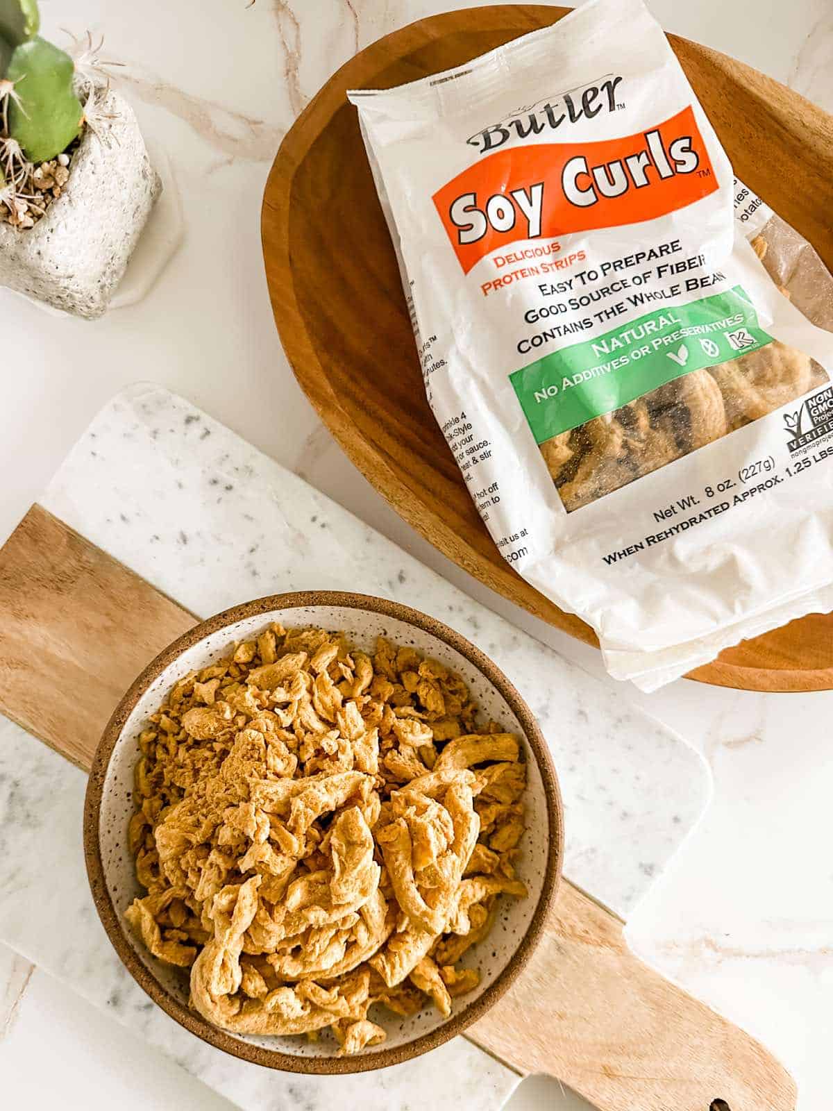 A package of Butler Soy Curls with a bowl of the soy curls next to it.