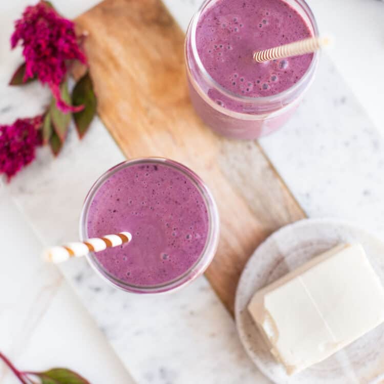 Two glasses filled with a tofu smoothie, next to a block of silken tofu.