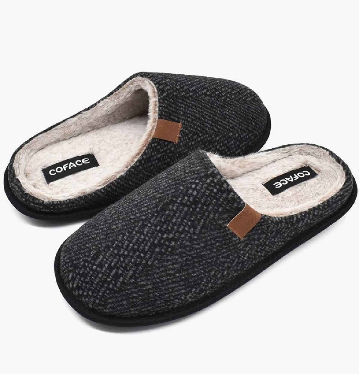 A pair of black twill memory foam slippers with tops opposite each other.