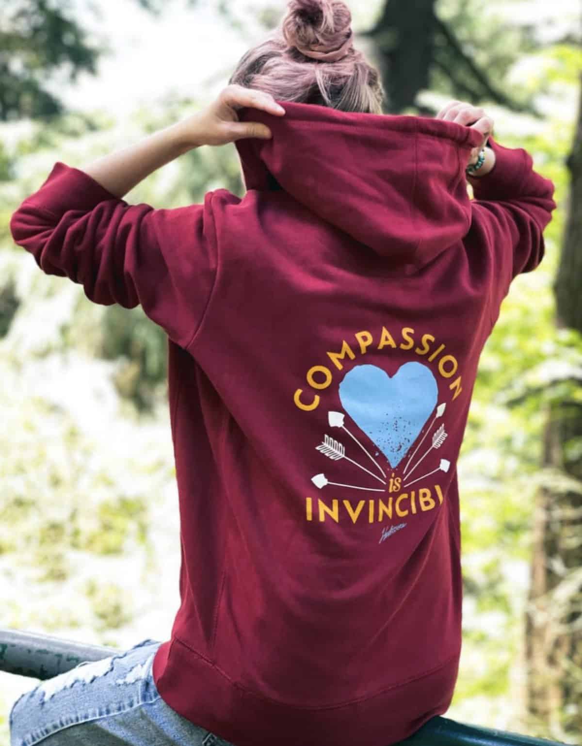 maroon vegan hoodie from herbivore clothing that says compassion is invincible