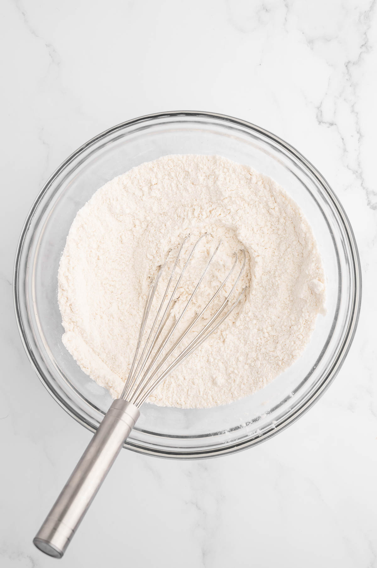 Dry bread ingredients in a glass bowl.