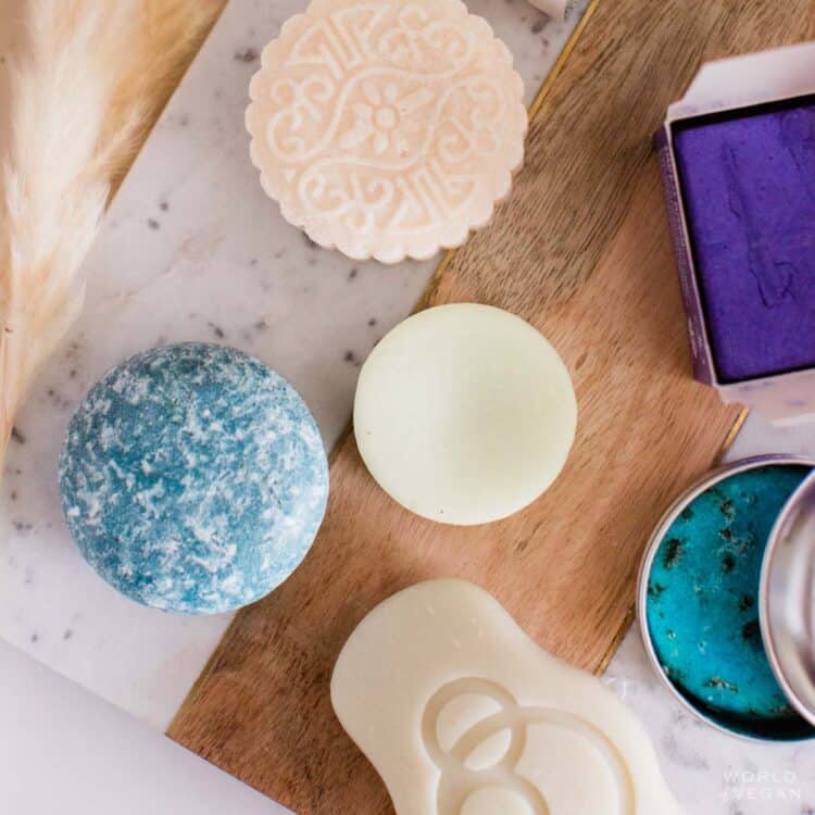 Various brands of vegan solid shampoo bars flatlay on a marble table.