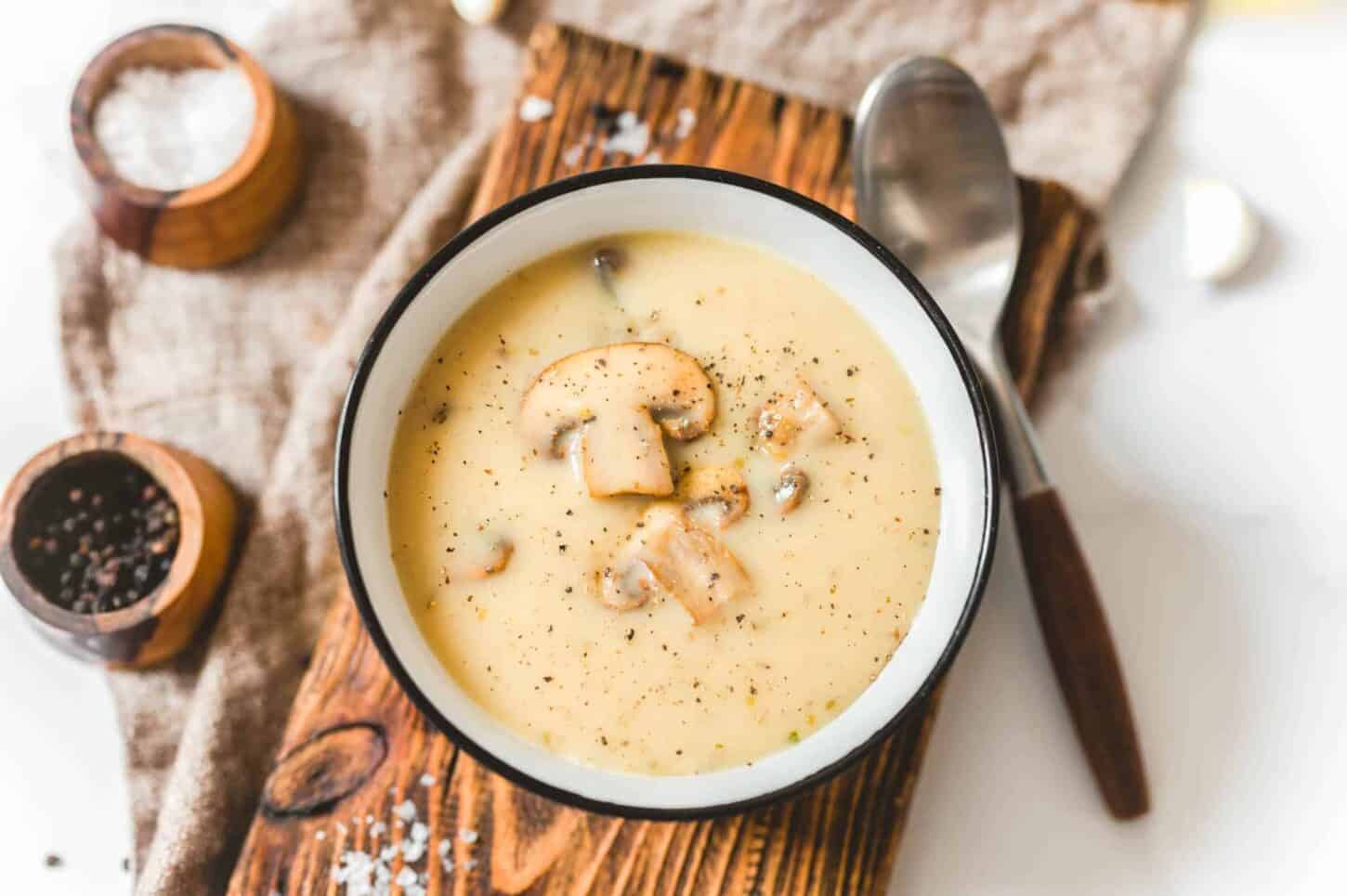 Easy Vegan Cashew Cream of Mushroom Soup in a Bowl on a Wood Cutting Board