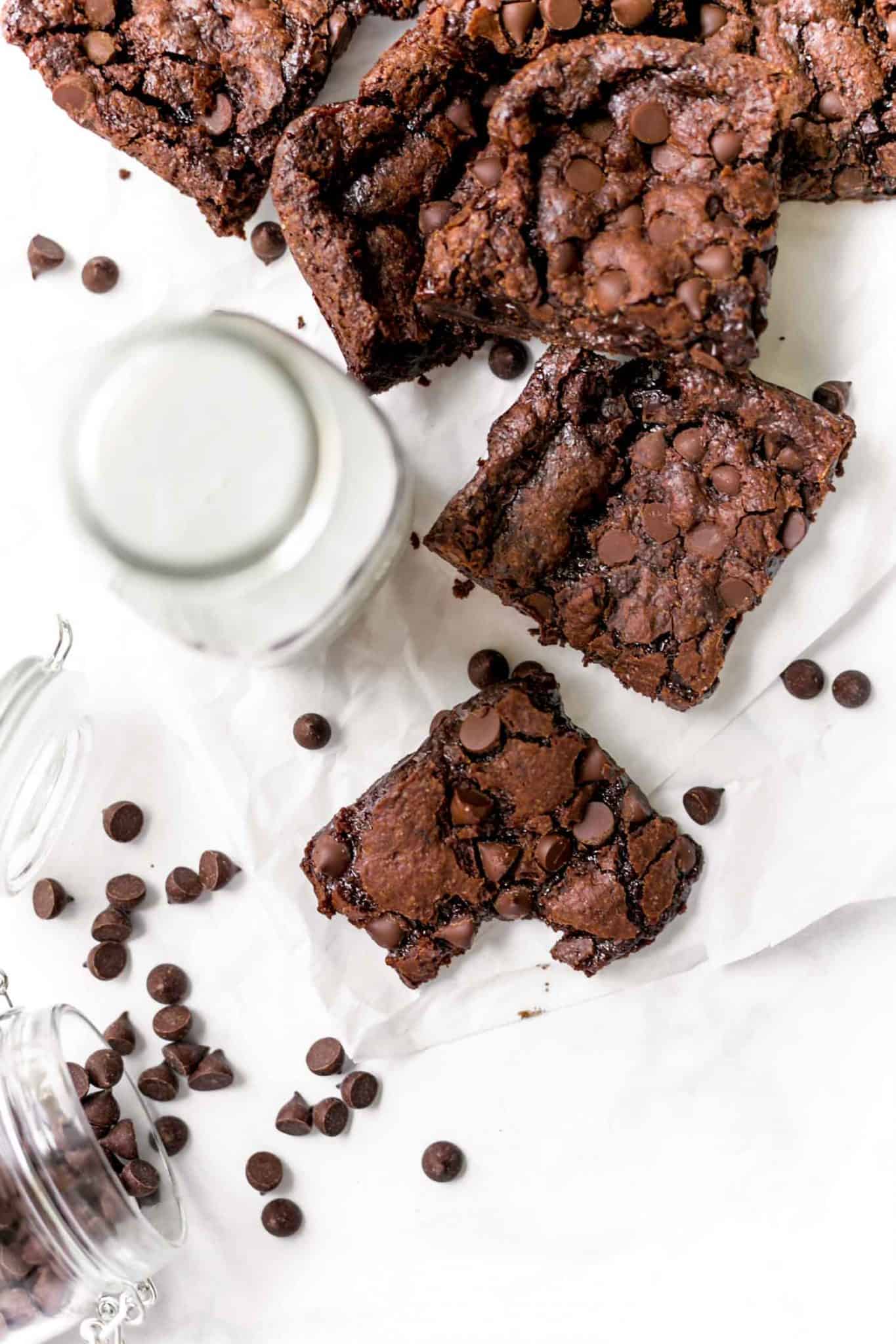Fudgy Vegan Brownies with a Crinkle Top Served With Milk And Sprinkled With Dairy-Free Chocolate Chips.