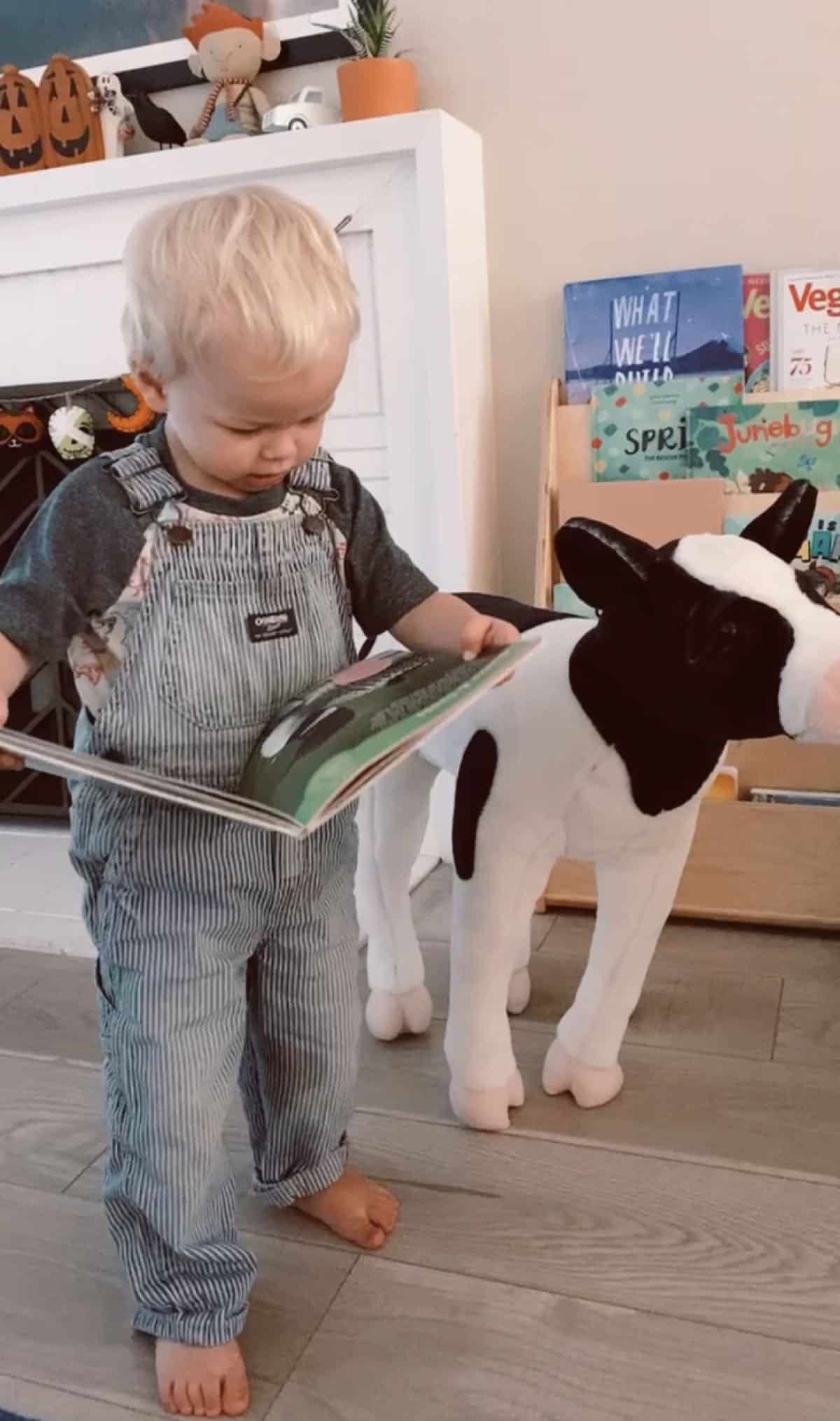vegan kid reading a book to his stuffed animal cow
