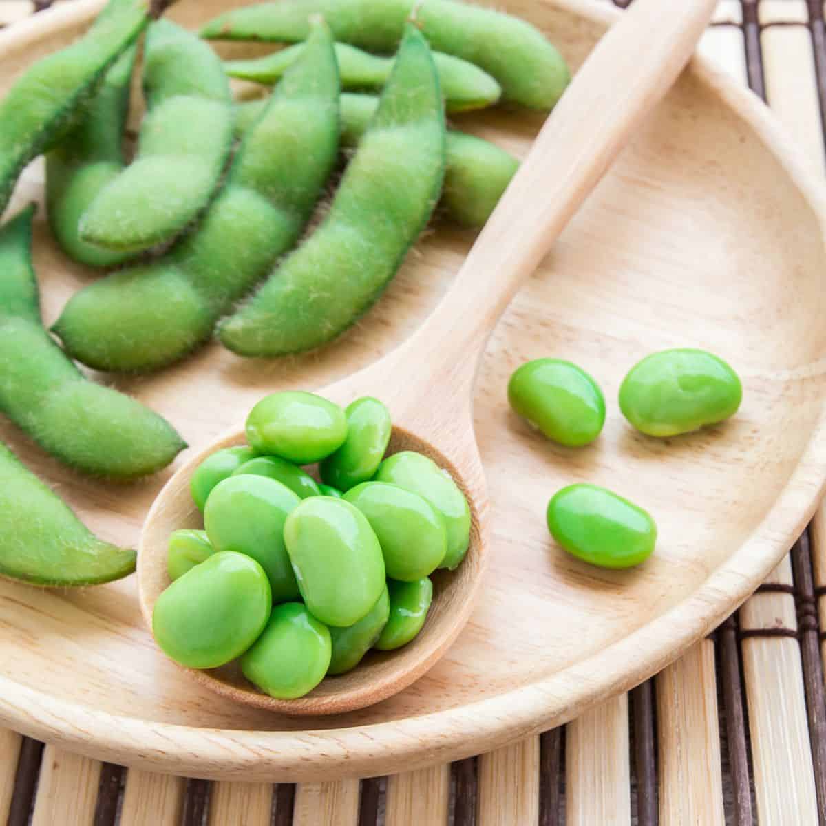 A plate with shelled soybeans and soybeans in the pod.