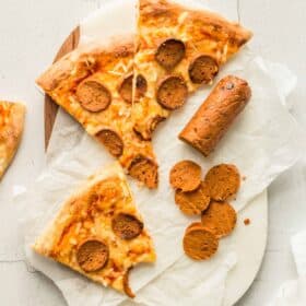 Homemade Vegan Pepperoni Pizza With Sliced Pepperoni On a Cutting Board