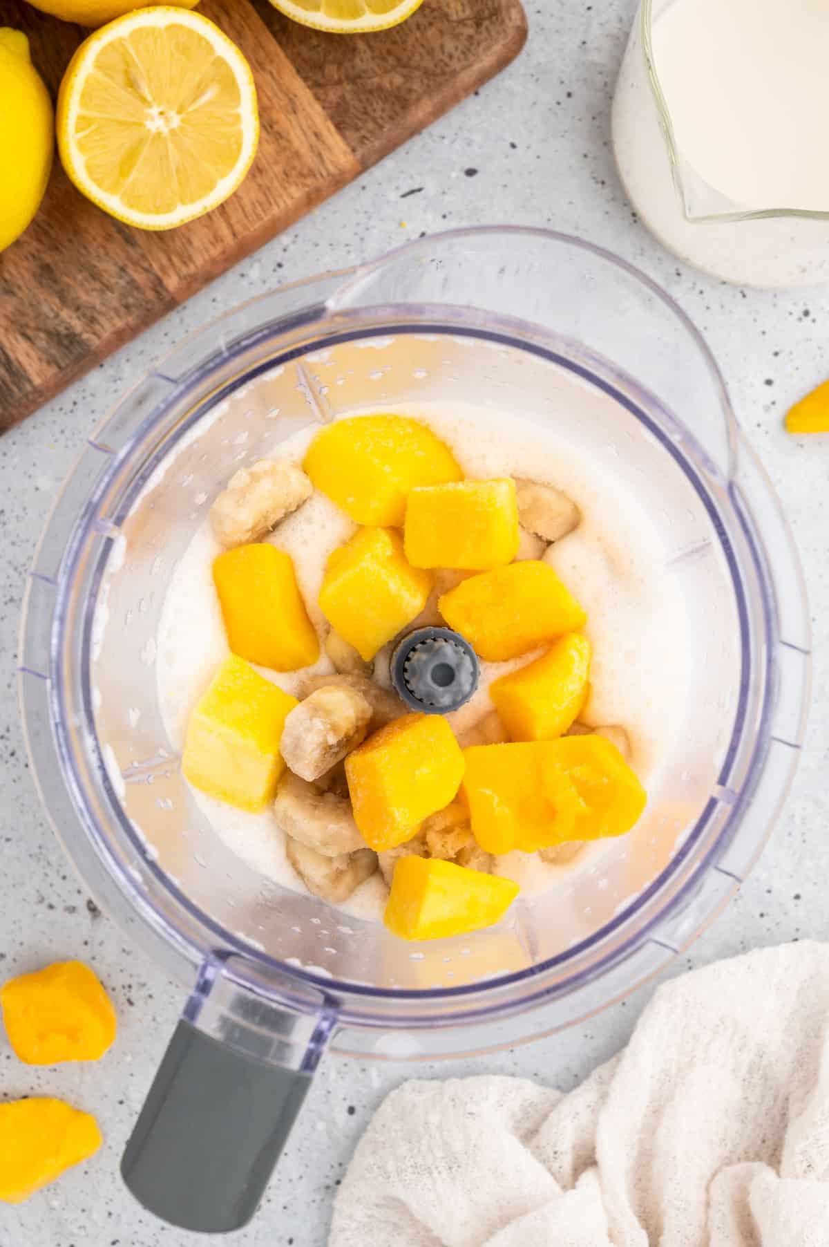Mango added on top of the other ingredients in the blender.