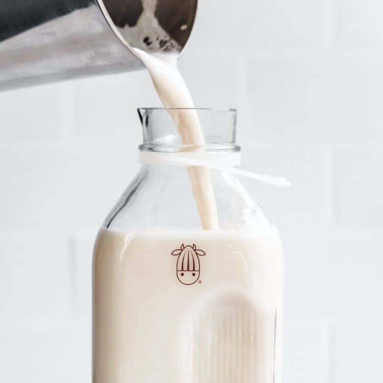 Almond Cow glass plant milk jug showing liter to gallon conversion.