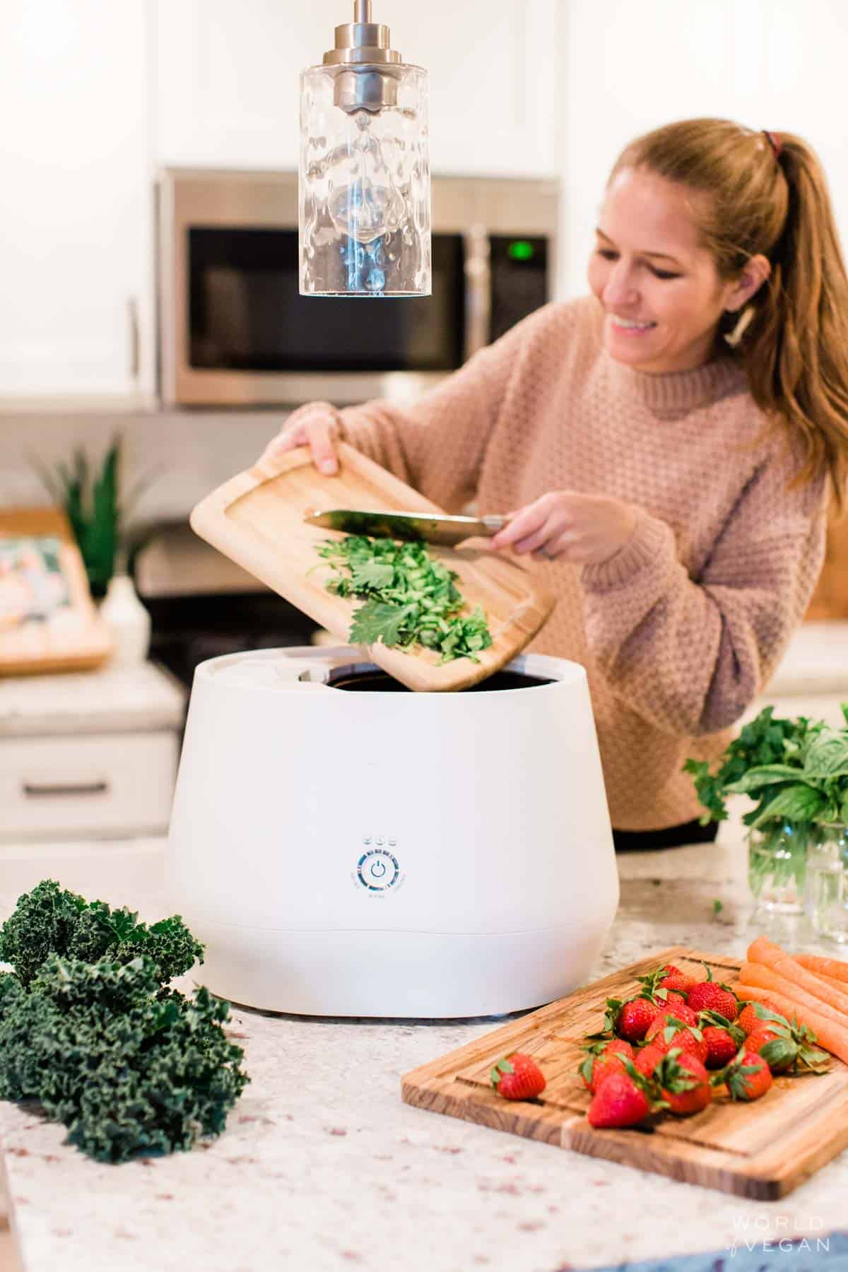 Michelle Cehn adding organic waste food scraps into the Lomi kitchen composter.