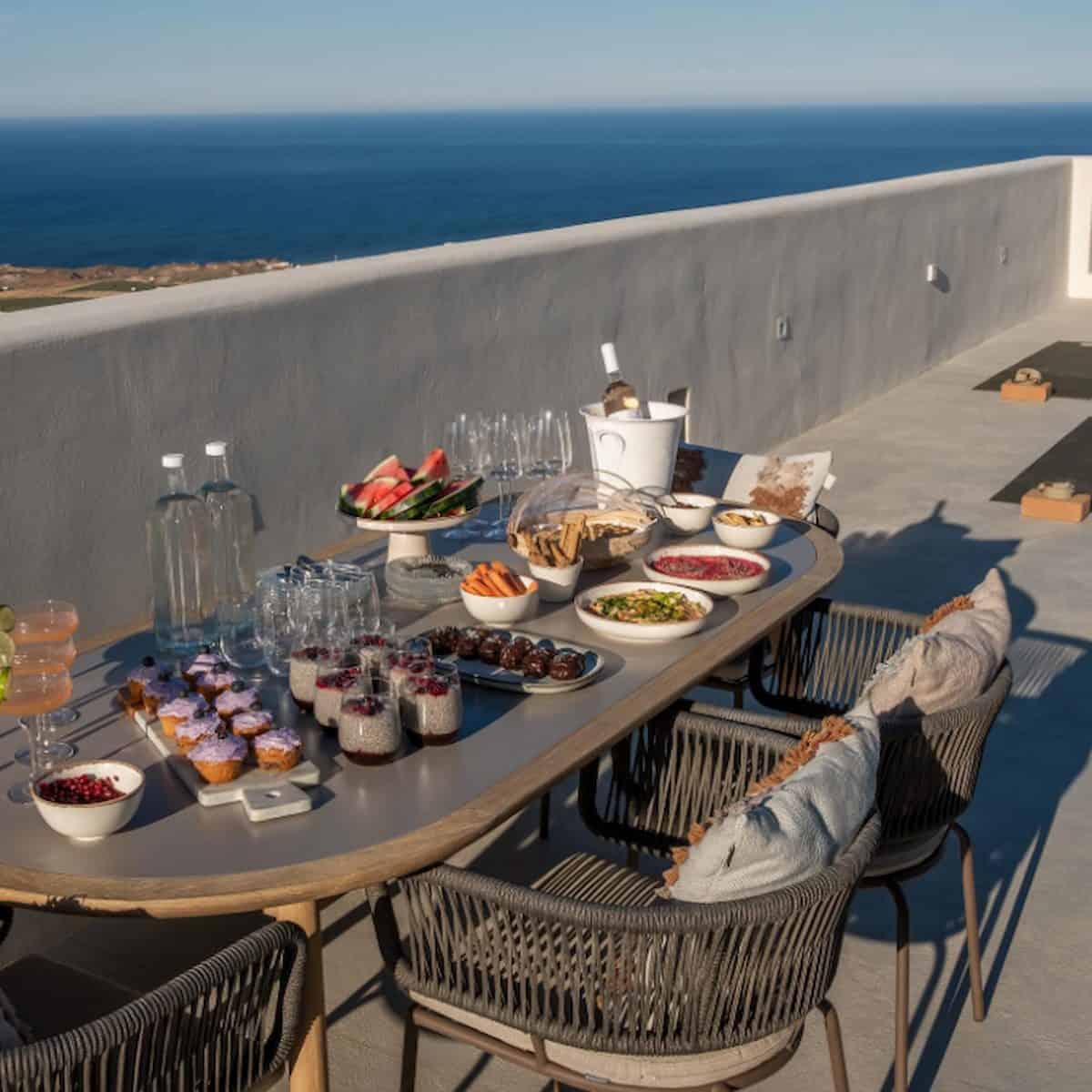 Table full of vegan dishes, overlooking the sea.