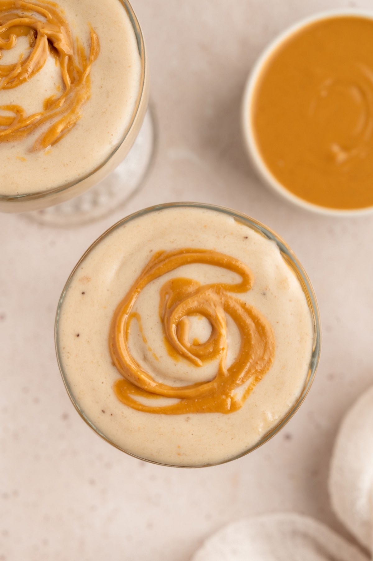 Drizzle peanut butter on top of the peanut butter banana milkshakes in glasses.
