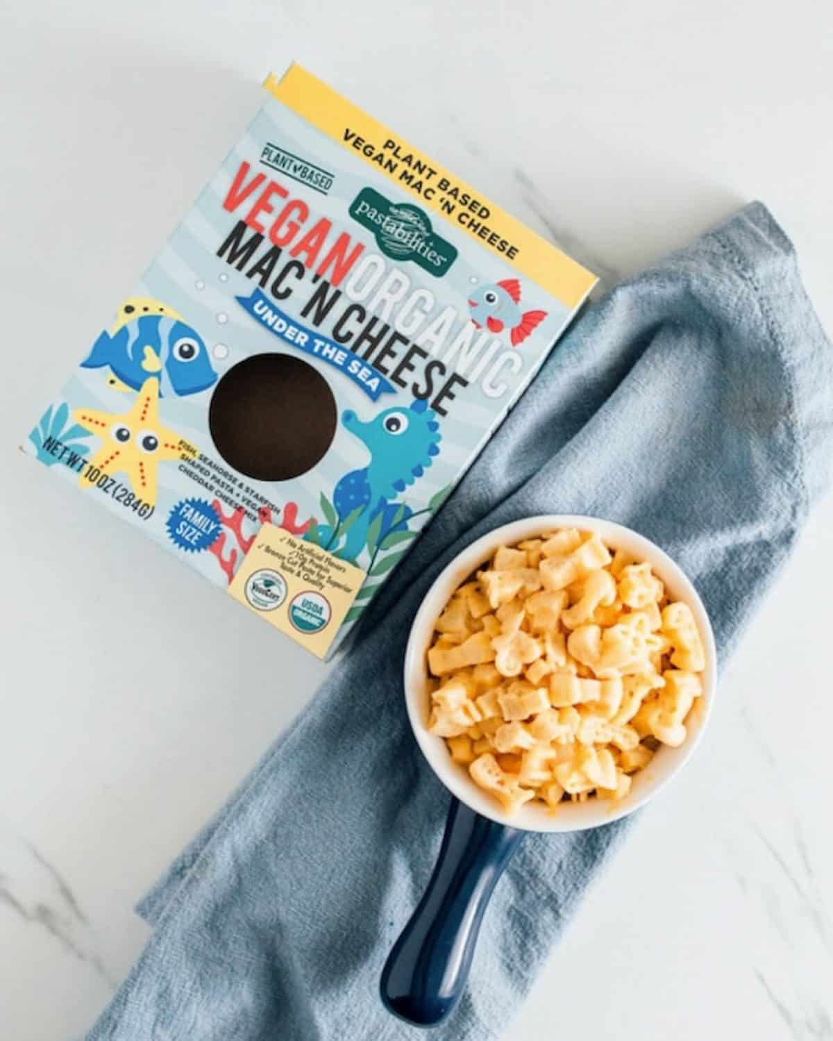 Bowl full of Pastabilities vegan organic mac 'n cheese next to the box.