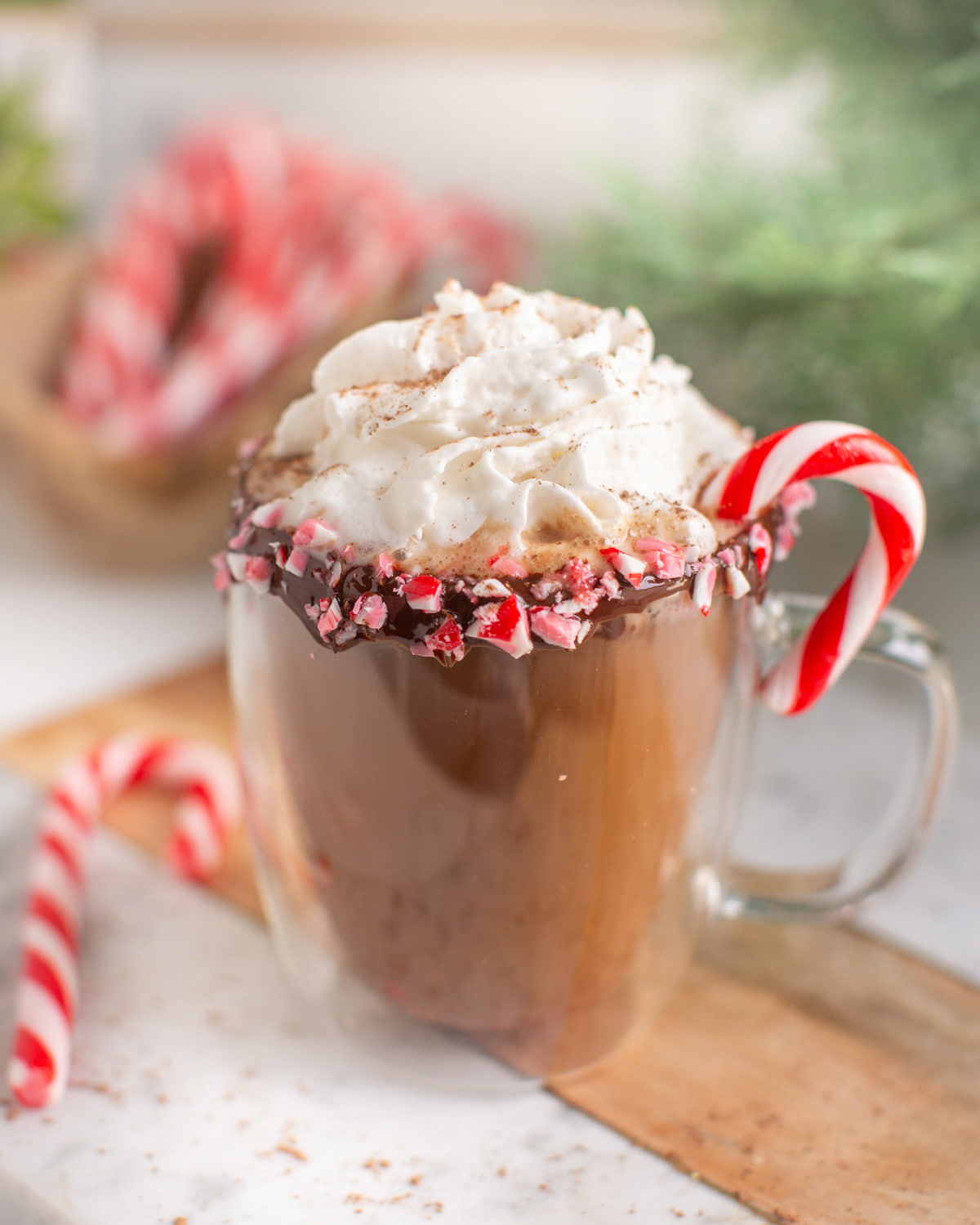 Dairy-free peppermint mocha in a glass mug with coconut whipped cream on top.