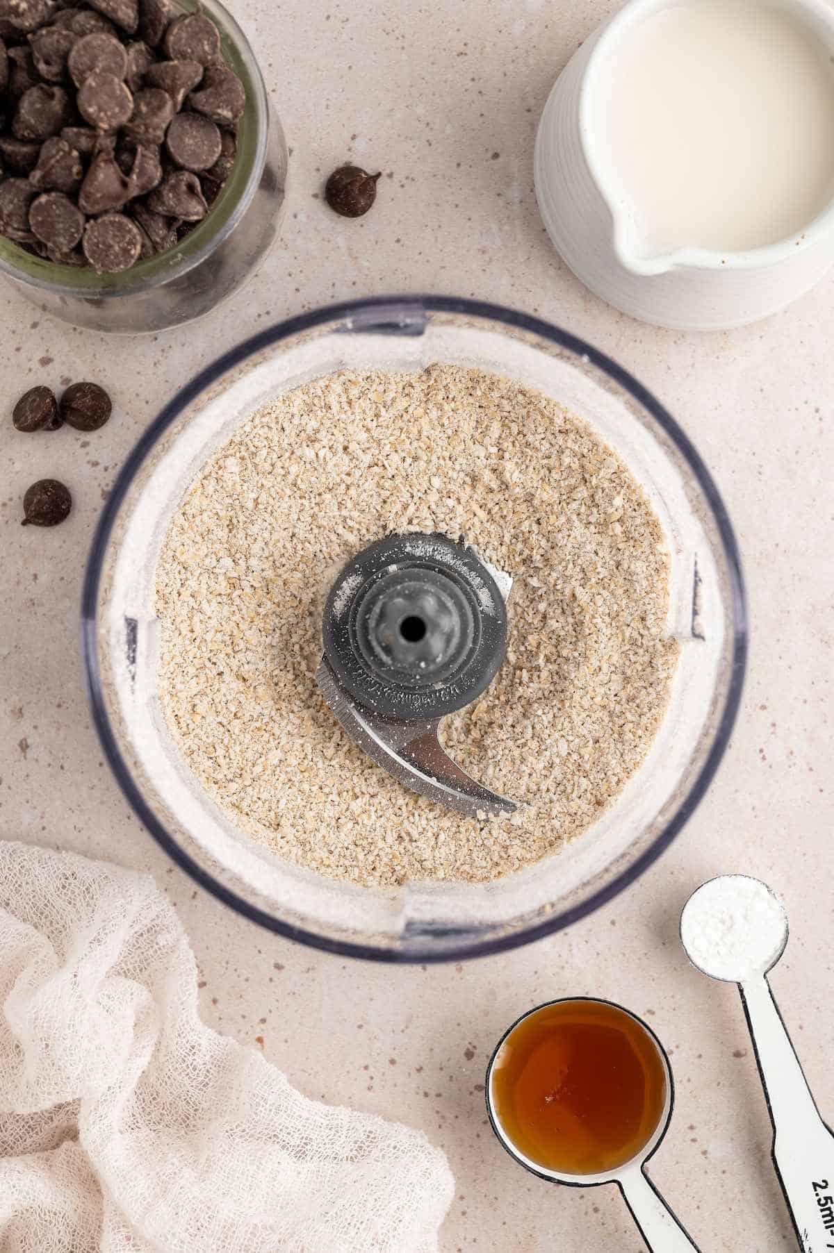 Oats in a food processor after being blended into a flour-like consistency.
