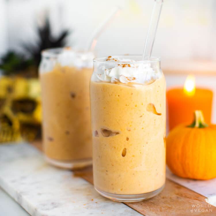 Pumpkin milkshakes in a glass with whipped cream and cinnamon on top.