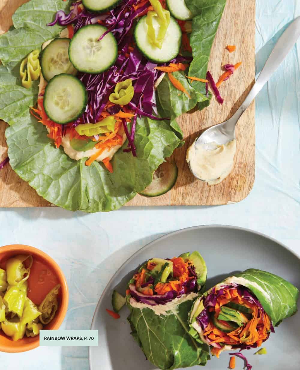 Rainbow collard wraps assembled and also open with various veggies inside like cabbage, cucumber, carrots, peppercinis, and hummus.