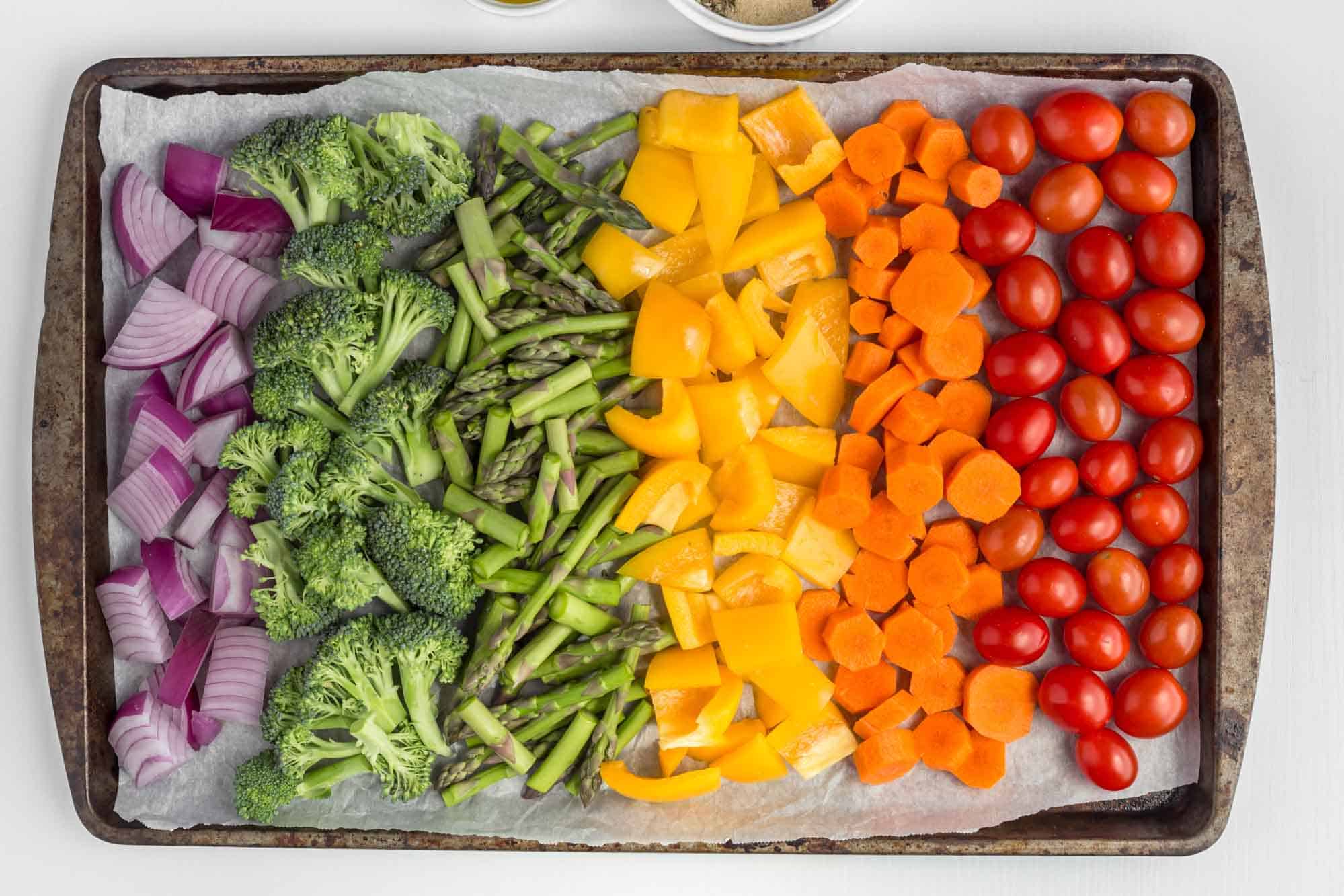 Rainbow Roasted Vegetables Laid Out on a Large Baking Pan Onion Broccoli Pepper Carrots Tomatoes