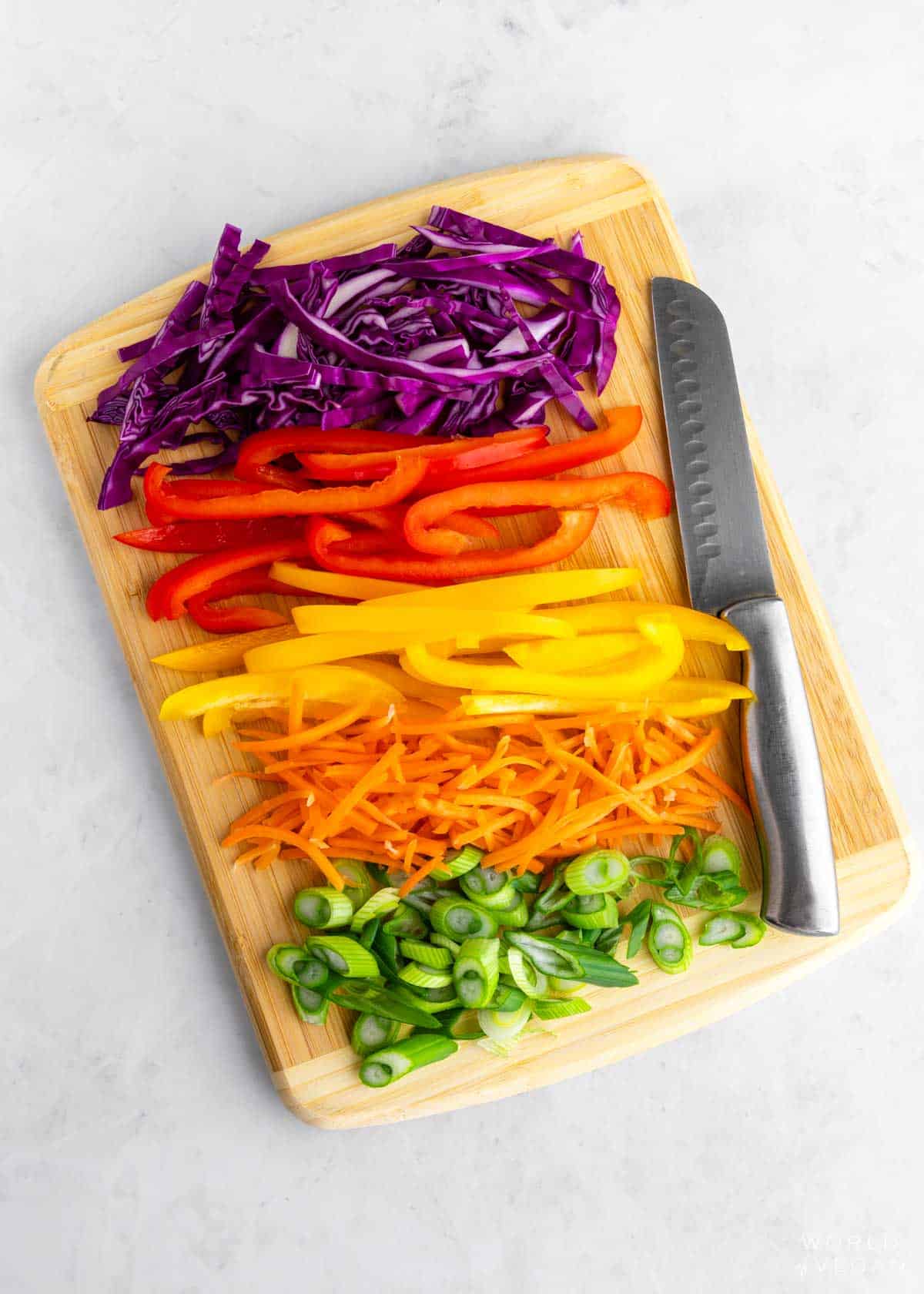 Chopped rainbow vegetables with red, orange, yellow, green, purple.