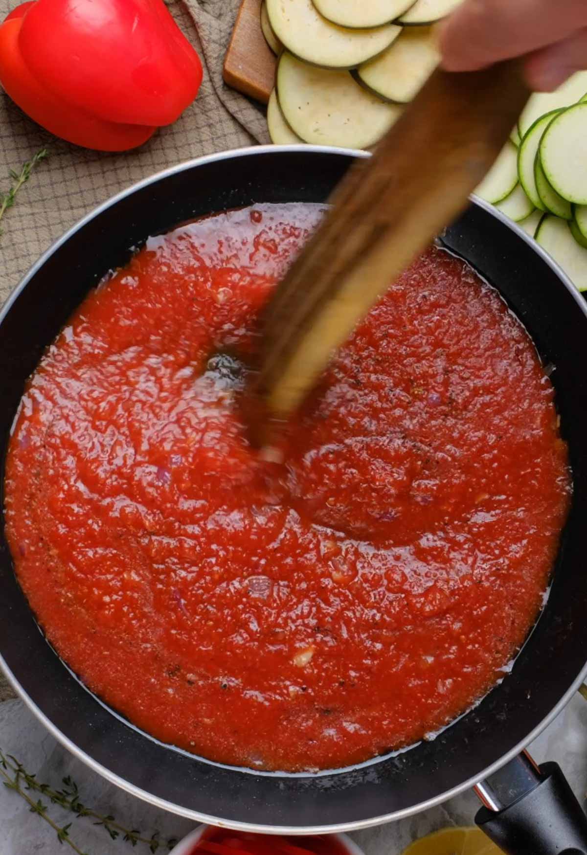 Tomato sauce being simmered in a sauté pan.