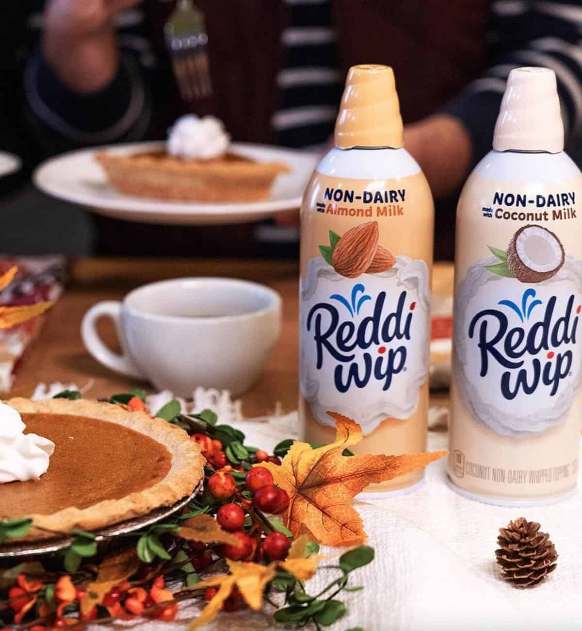 Two cans of vegan Reddi Wip made from coconut and almond with holiday pumpkin pie. 