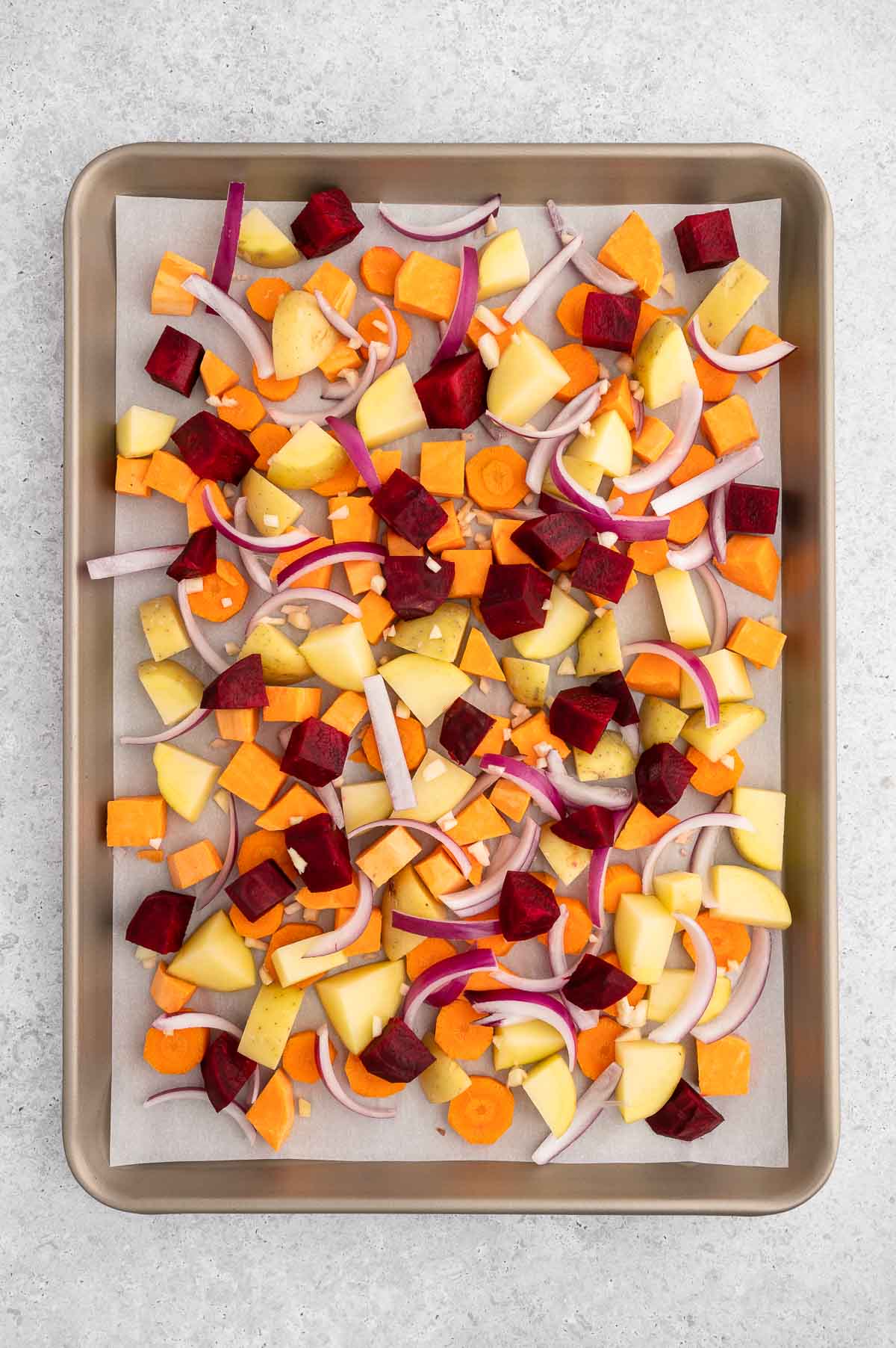 Root vegetables chopped and prepped on a baking sheet.