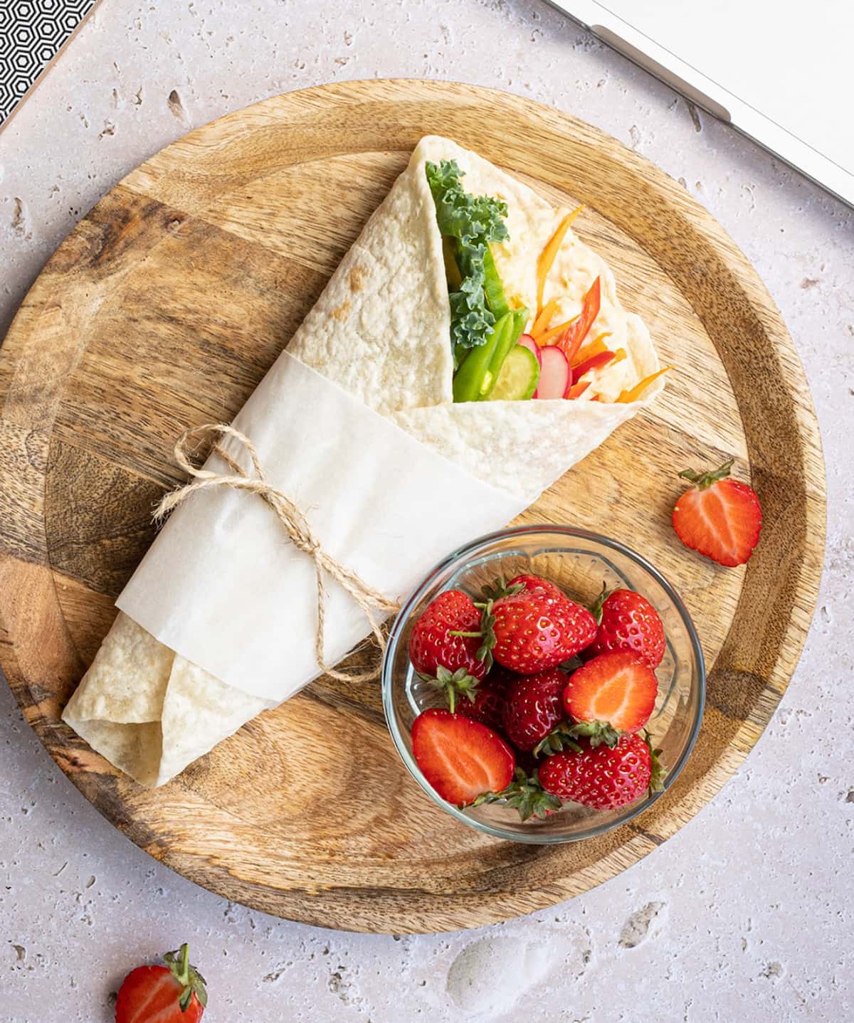 A veggie wrap on a wooden tray made with Rudi's tortilla.