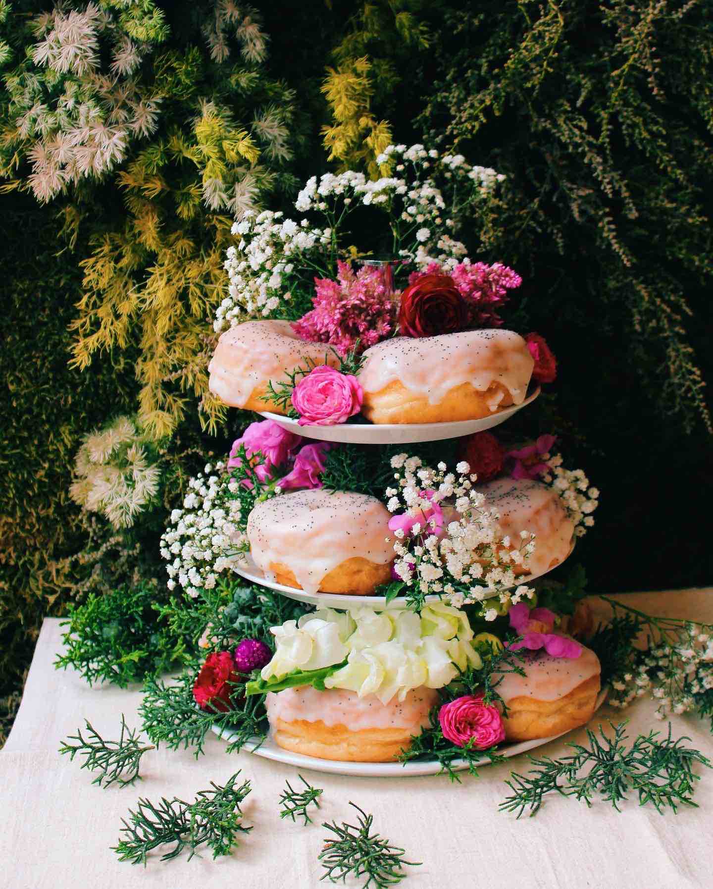 Scoop n Dough vegan doughnuts wedding party stand decorated with flowers