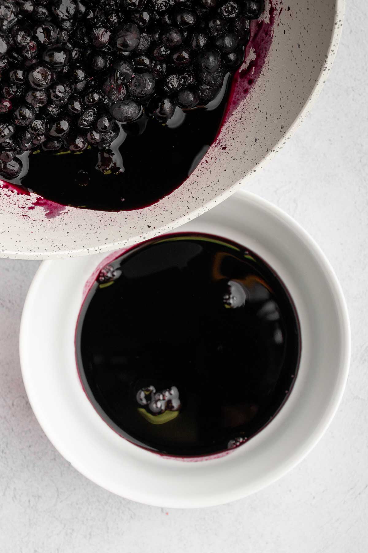 Separating the blueberry liquid into another bowl.