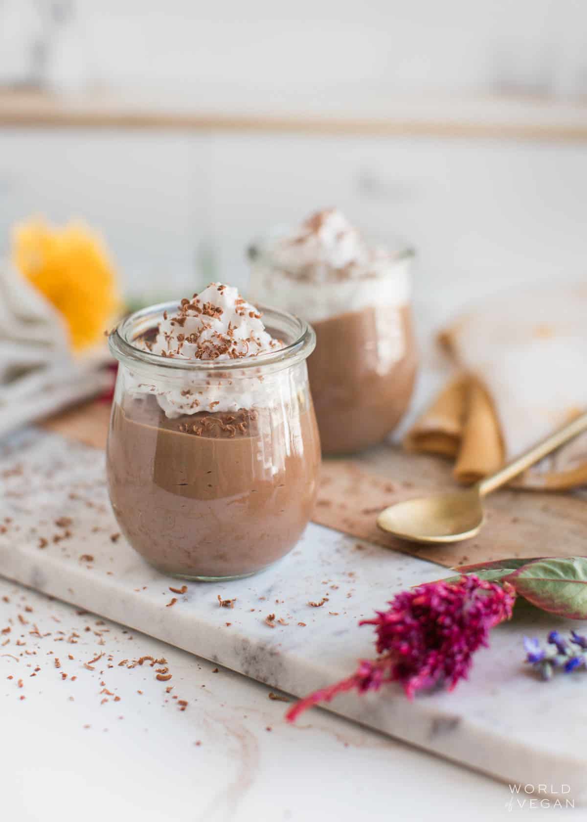 Two jars of silken tofu chocolate pudding with vegan whipped cream.