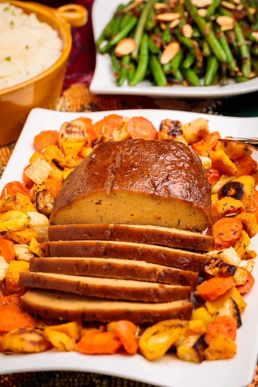 Sliced Plant Based Seitan Turkey Roast with Roasted Veggies for Thanksgiving