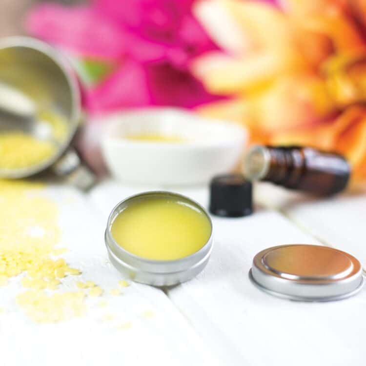 Solid perfume in a tin jar with candelilla wax sprinkled around it.