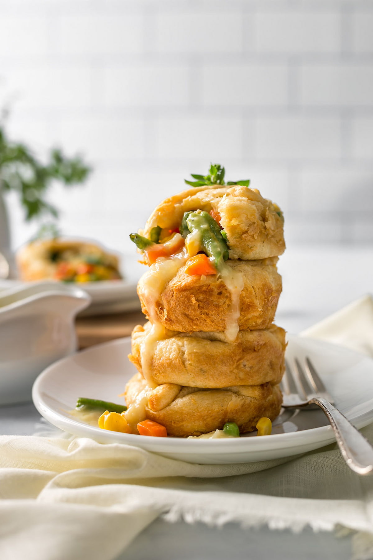 Mini vegan pot pies stacked on one another on a plate.