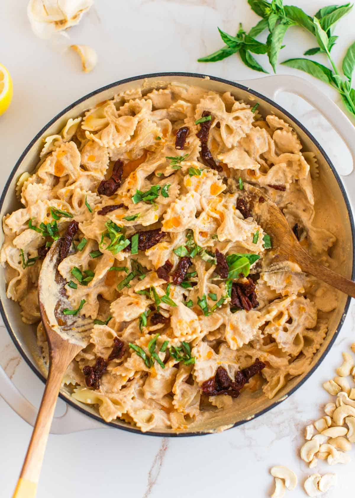 Tomato sauce alfredo sauce mixed with pasta in a pan.