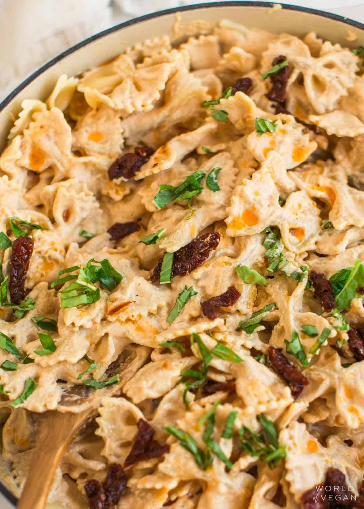 Up close of sun-dried tomato sauce mixed with pasta.