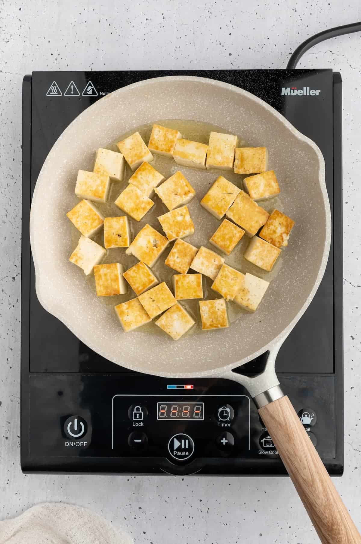 Browned tofu cubes in a pan.