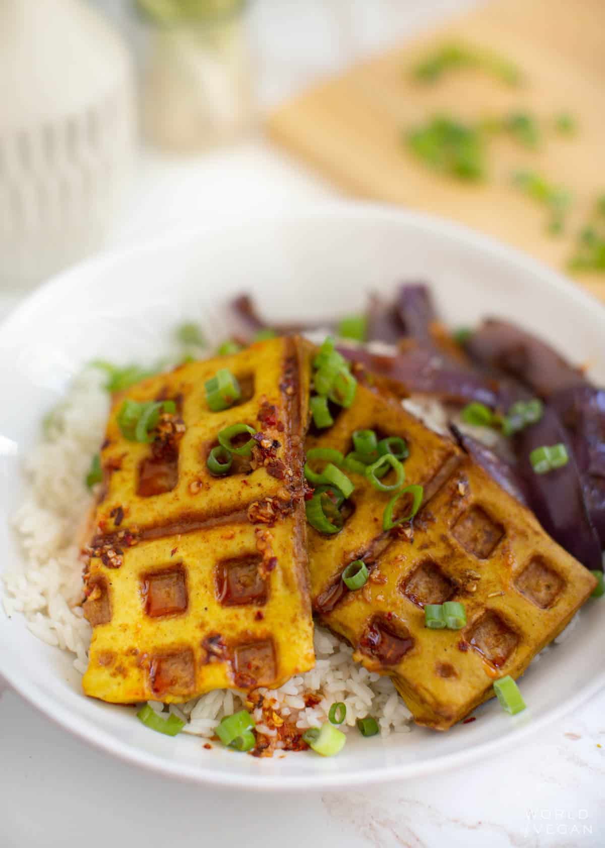 Waffles made out of tofu pressed in a belgian waffle iron served over rice and garnished with green onions. 