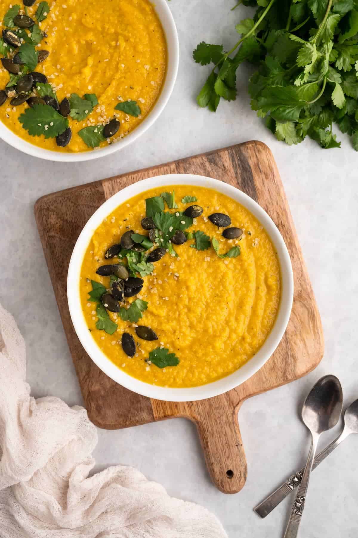 A bowl of toor dal on a wooden serving board.