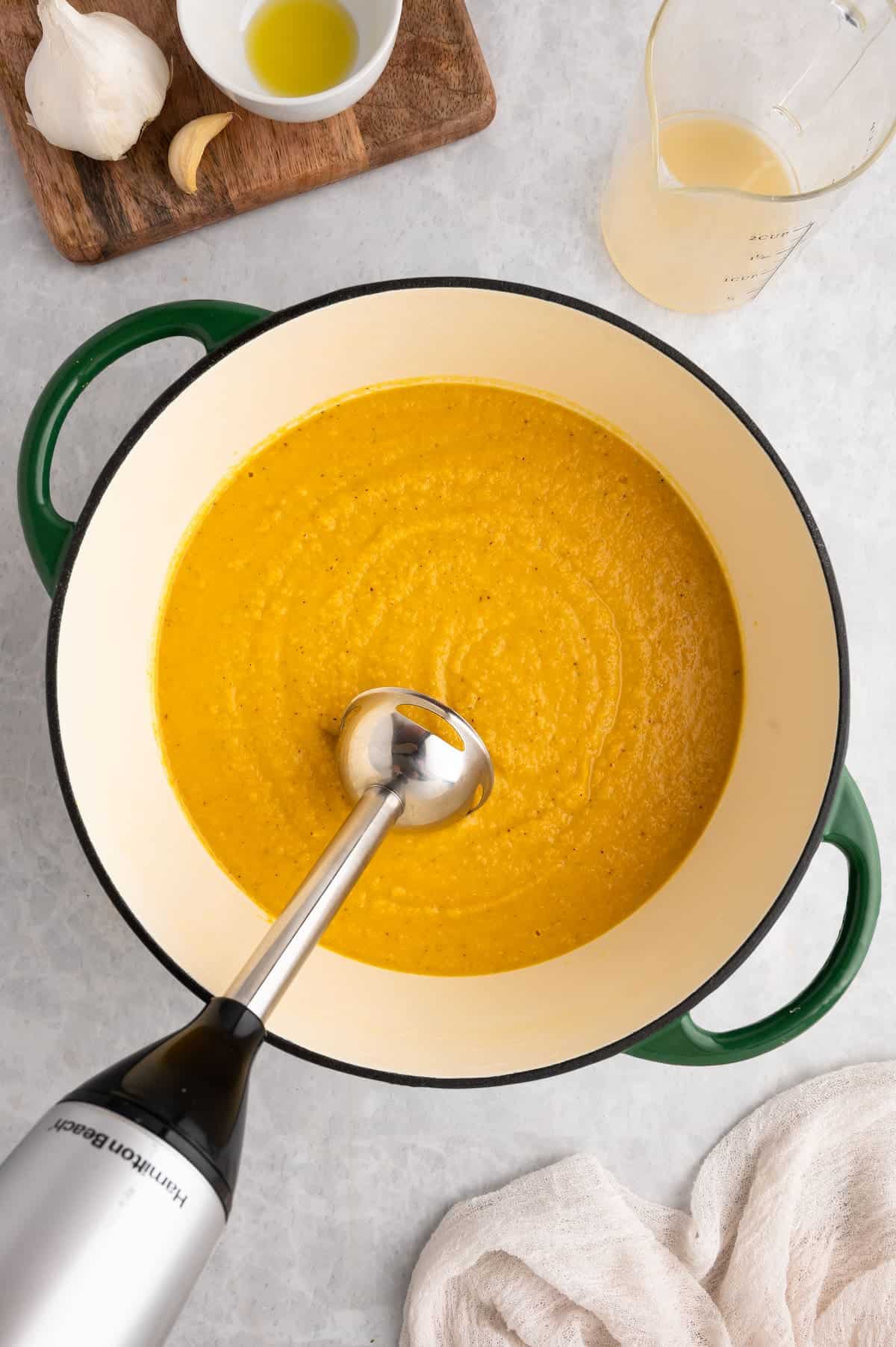 Toor dal being pureed with a stick blender.