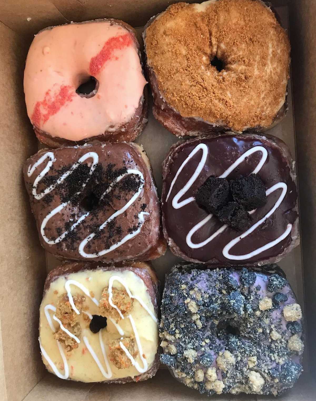 An assortment of vegan donuts in a box from Valkyrie Doughnuts.