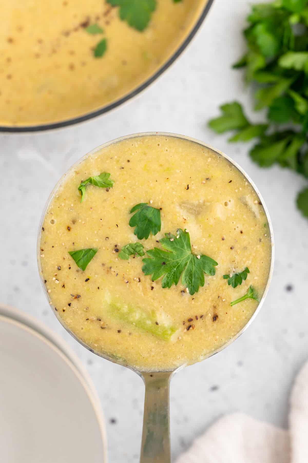 Vegan asparagus soup in a ladle.