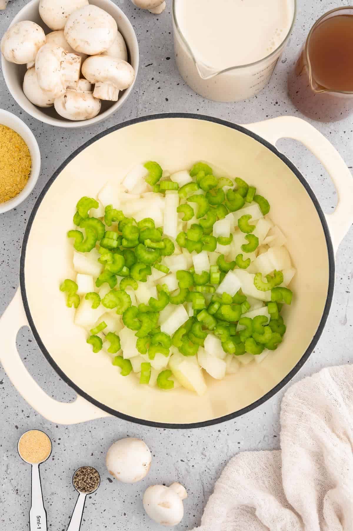 Celery and onion sautéeing in pot.